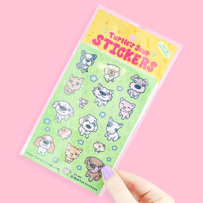 Hand holding cute animal sticker sheet with big-head pets and star accents