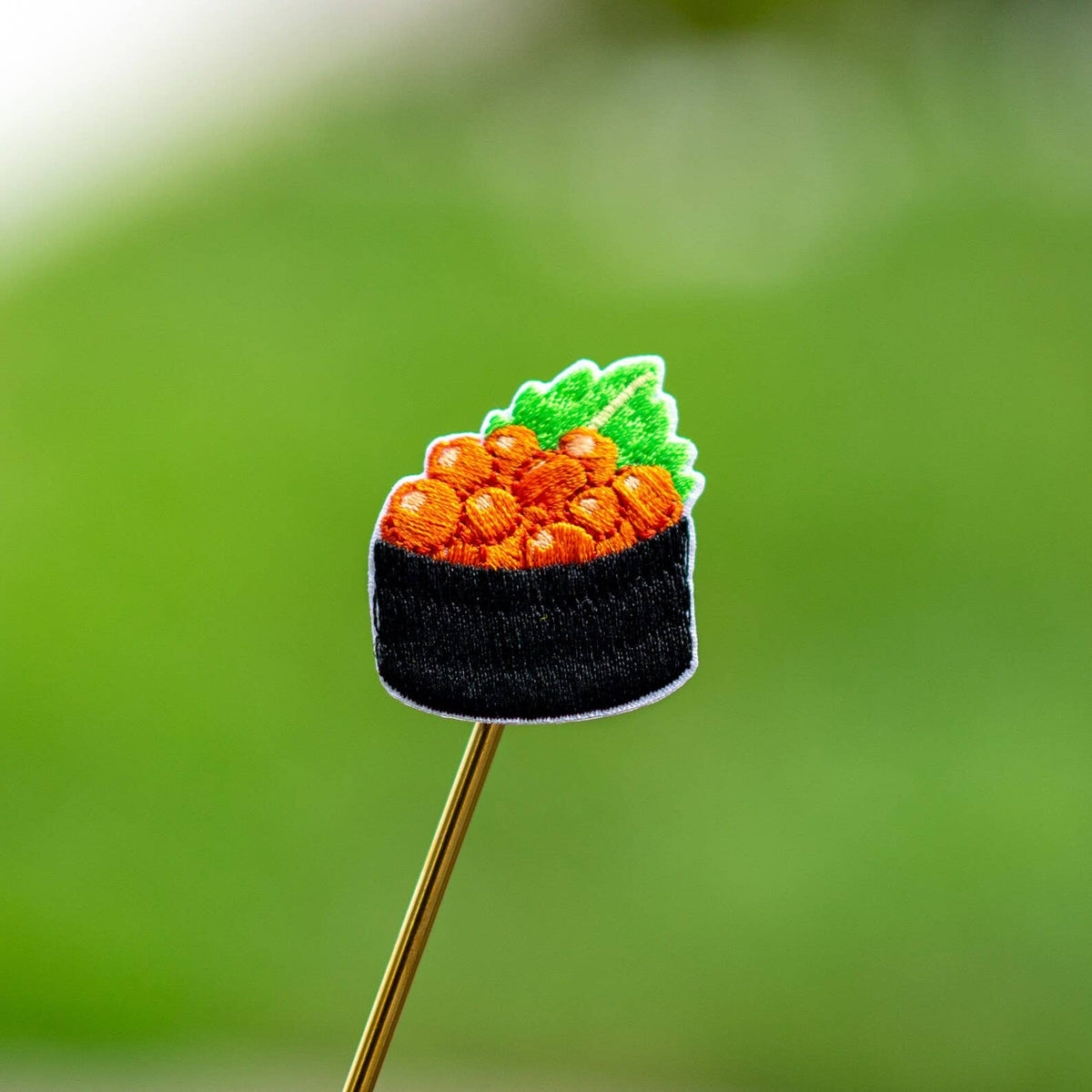 Orange shrimp nigiri iron-on patch on wooden stick