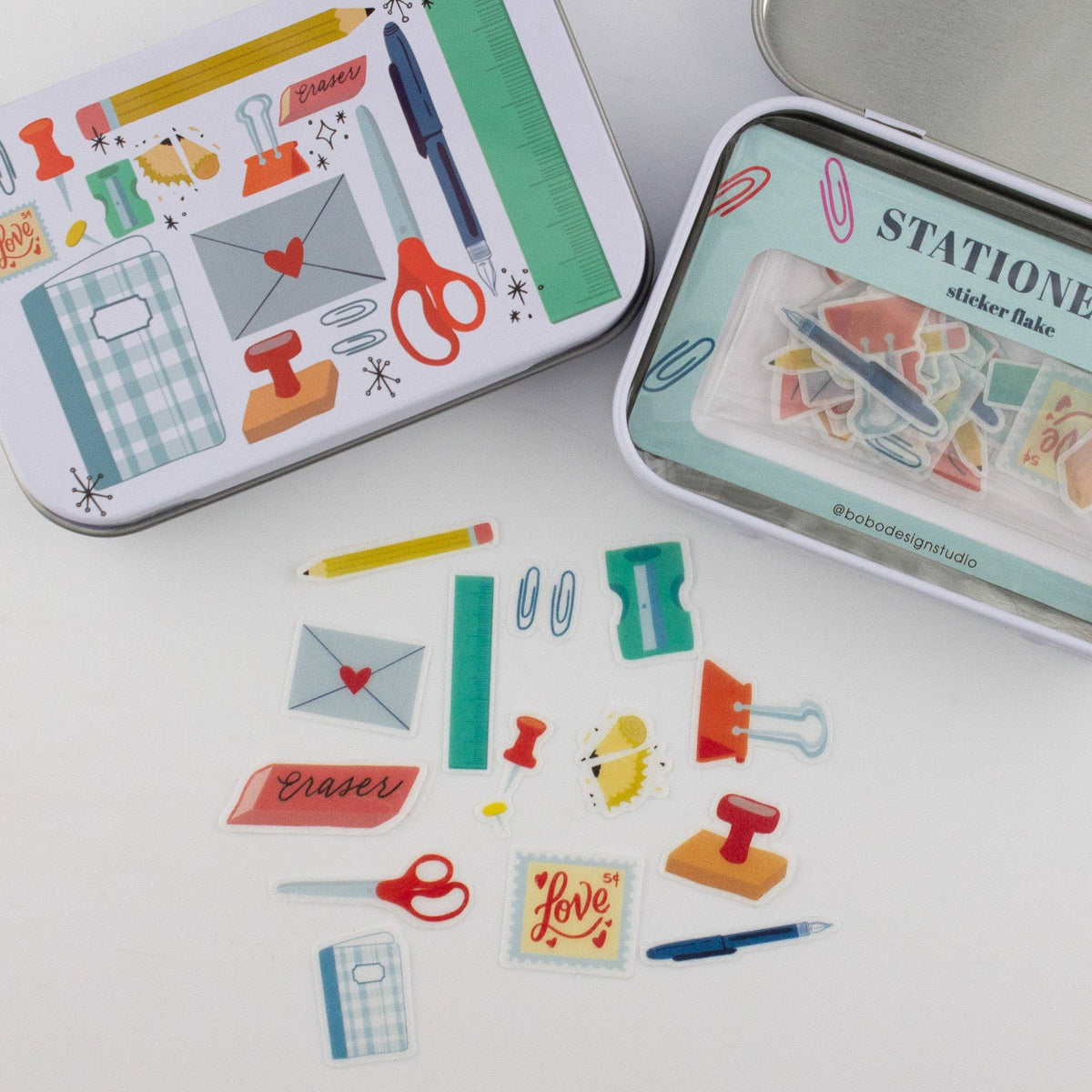 Stationery trinket tin set with illustrated fronts and scattered sticker flakes