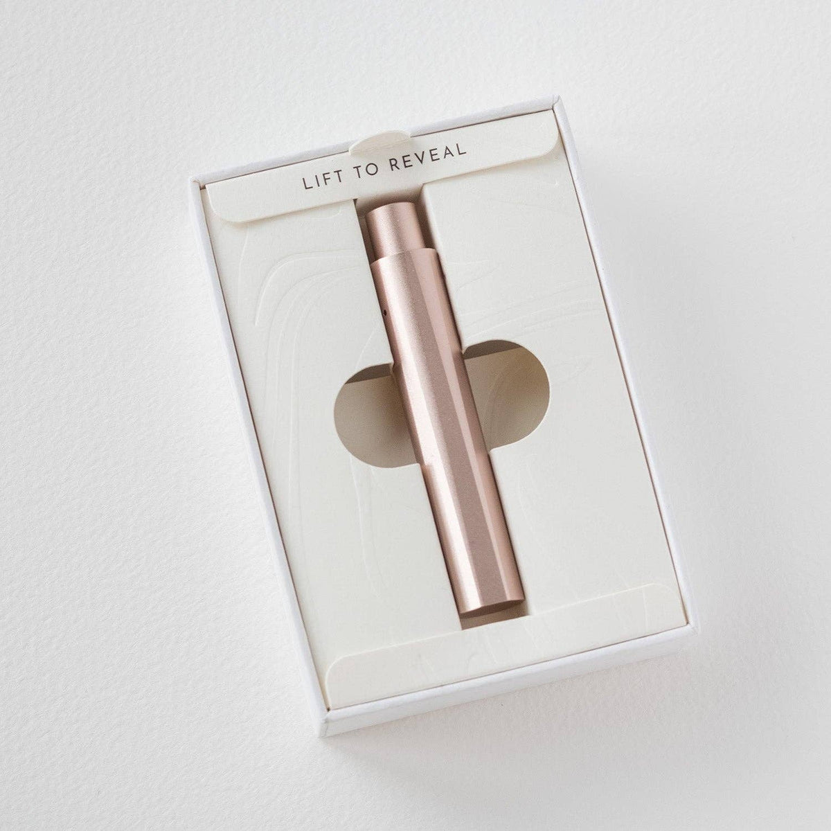 Refillable writing pen in gift box, rose-gold barrel visible through window