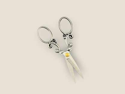 Arabesque scissors with ornate scroll handles, three oval loops, and gold jewel accents