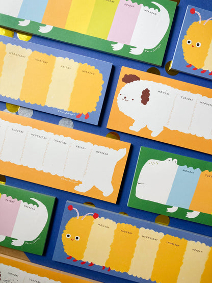 Weekly planner pads with caterpillar and other animal designs in assorted colors