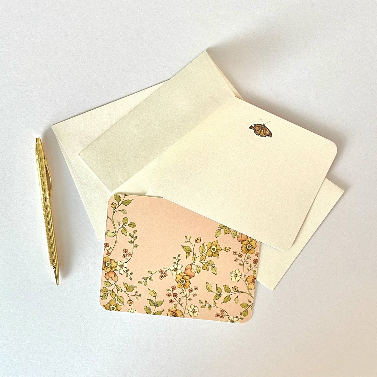 Set of cream letter envelopes with butterfly and floral designs, plus matching blank inserts.