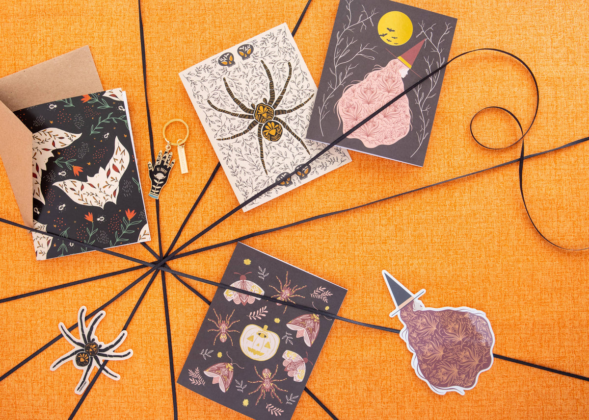 Witch greeting card with gold moon and floral dress among Halloween-themed cards