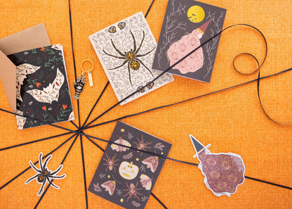 Witch greeting card with gold moon and floral dress among Halloween-themed cards
