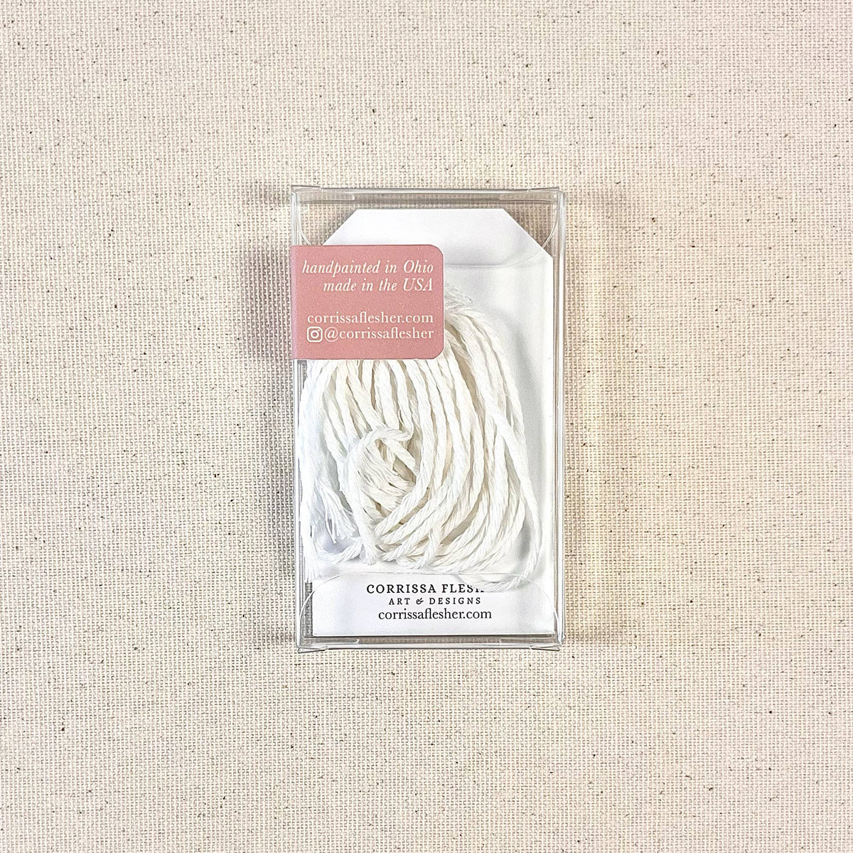 Clear box containing white twine string for gift tags