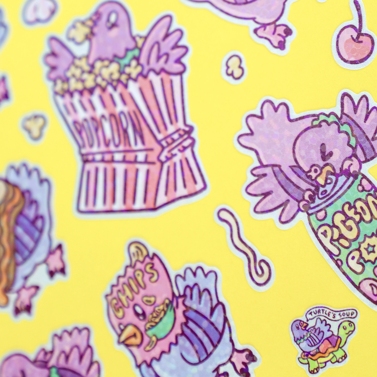 Close-up of sticker sheet showing purple birds, popcorn buckets, hearts and snacks
