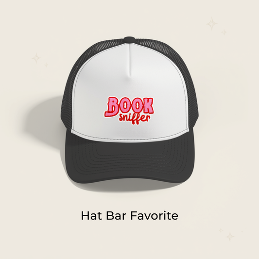 Embroidered iron-on patch on front of white-and-black baseball cap, red stitched text