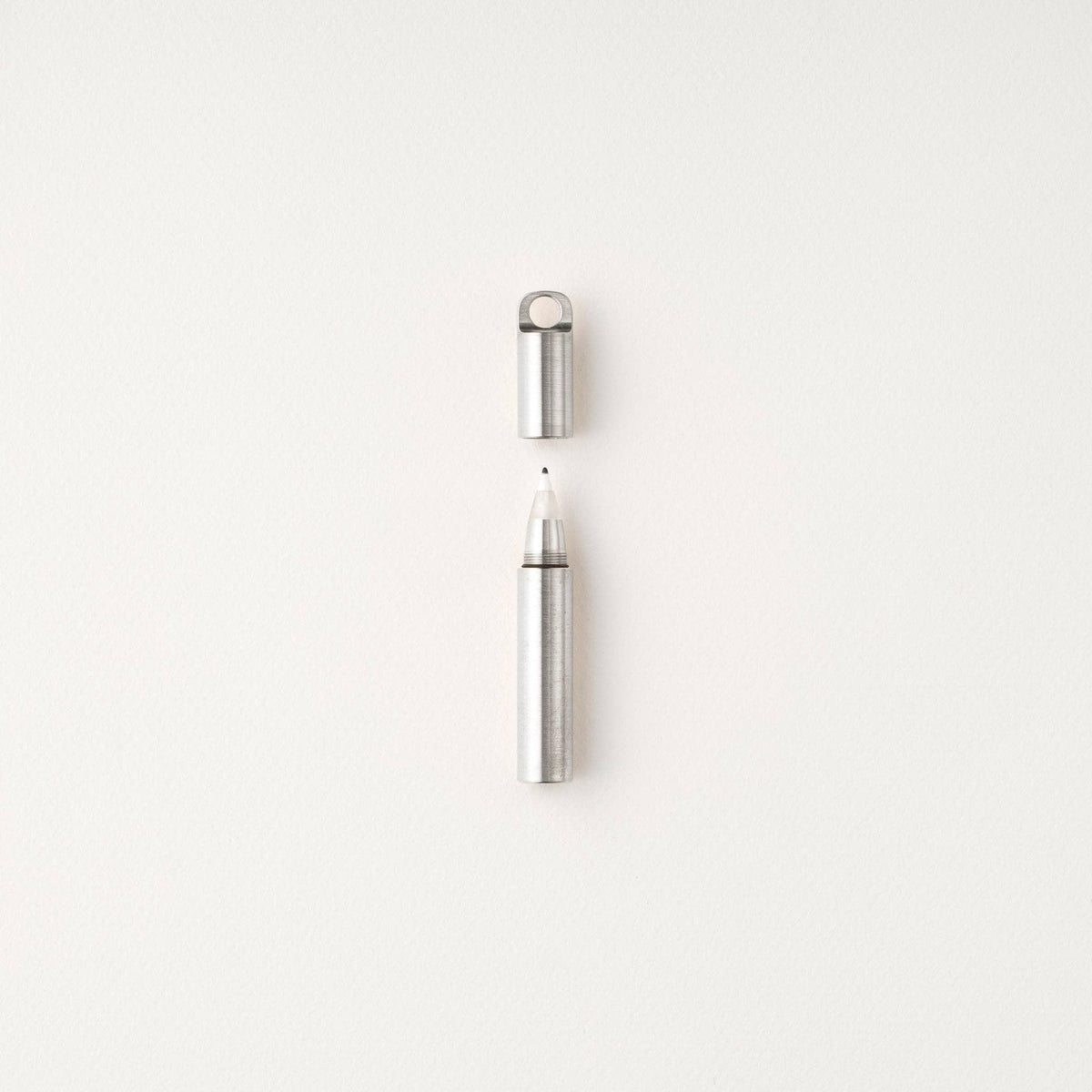 Refillable travel pen with silver barrel, silver cap, and open tip