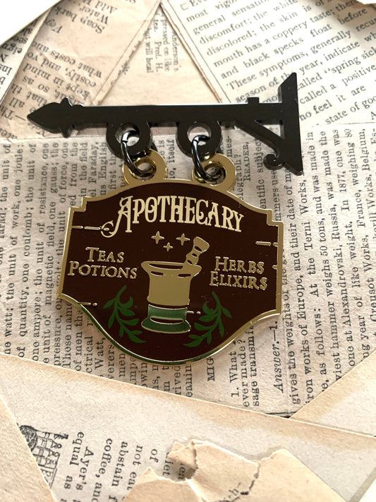 Apothecary shop enamel pin with Apothecary crest and gold-and-black ring backing