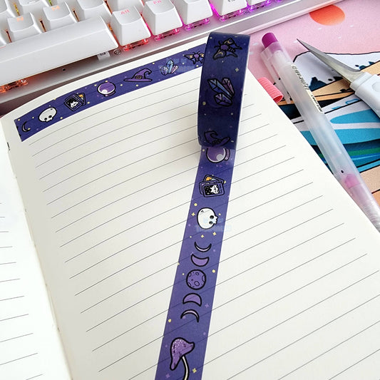 Witchy-themed washi tape strip with purple night icons on a notebook