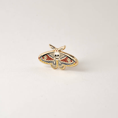 Enamel death moth skull pin with spread wings and gold-tone outline