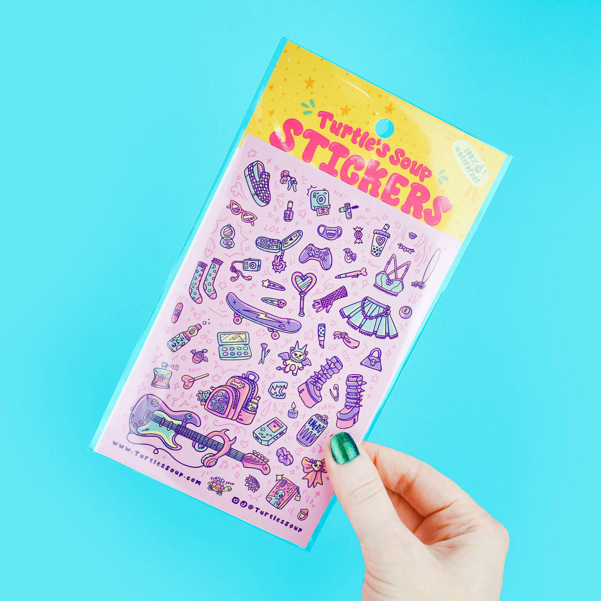 Sticker sheet with purple fashion accessory icons, held in a hand