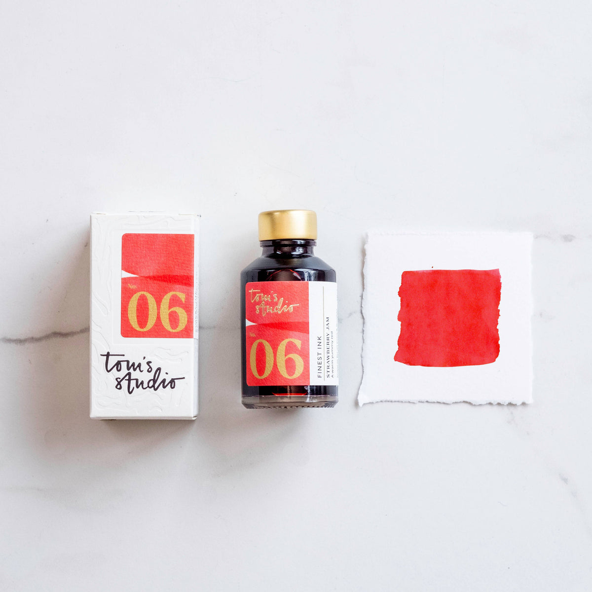 Fountain pen ink bottle with strawberry-red sample swatch and labeled box