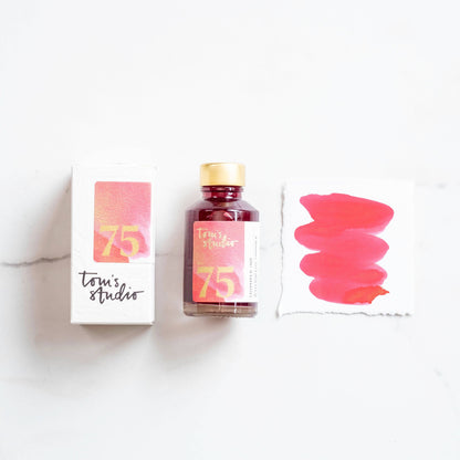 Watermelon shimmer ink bottle with pink-red glitter, gold cap, and 75 label