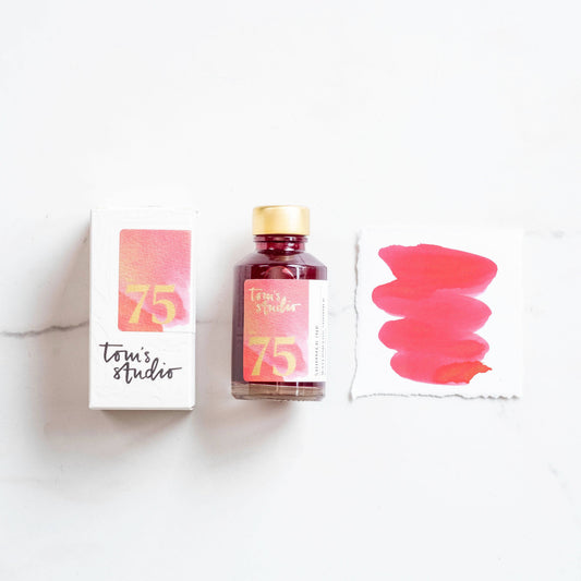 Watermelon shimmer ink bottle with pink-red glitter, gold cap, and 75 label