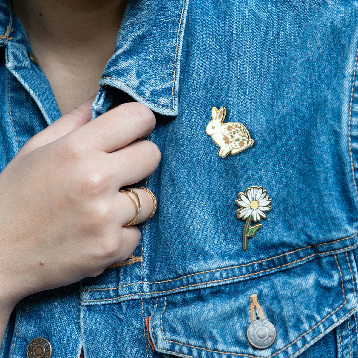 Rabbit pin on blue denim jacket pocket, gold-tone with floral enamel