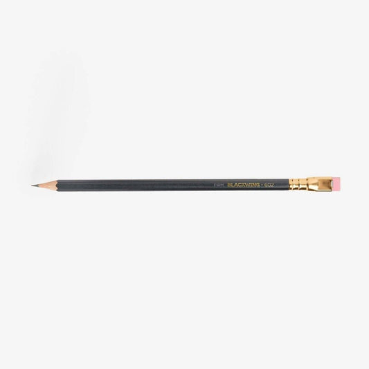 Blackwing 602 graphite pencil with gold ferrule and pink eraser cap, sharpened tip.