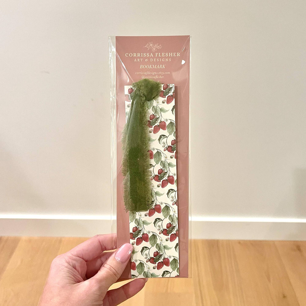 Branded strawberry bookmark in clear sleeve with green velvet ribbon trim