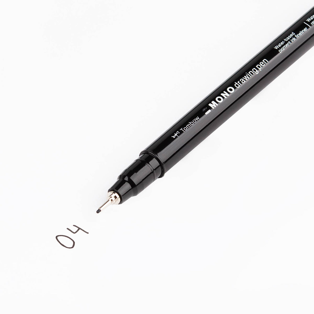 Black fine-tip drawing pen writing a small “0.4” sketch on white paper