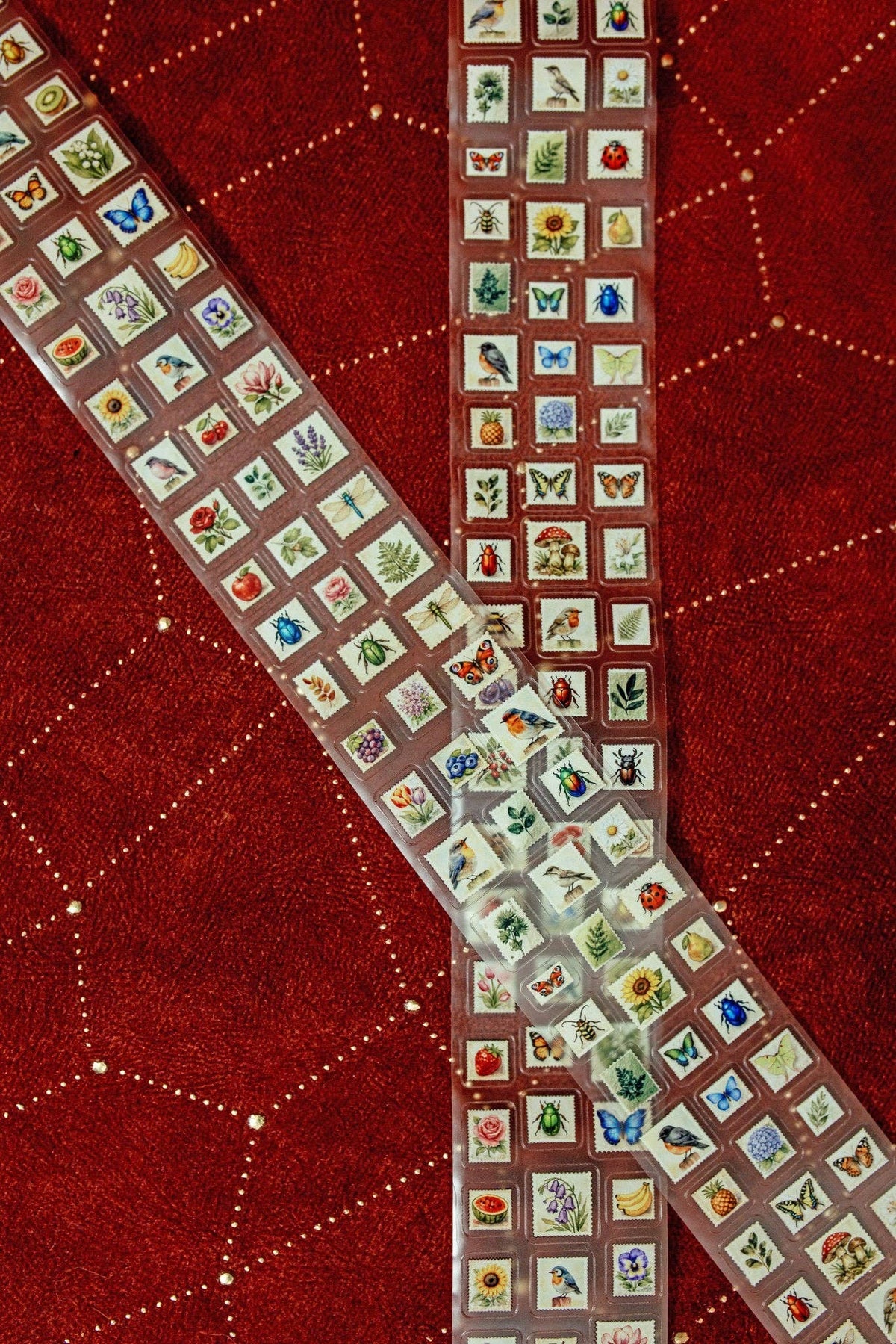 Transparent tape strip covered with mini postage stamps, folded and arranged in an S shape