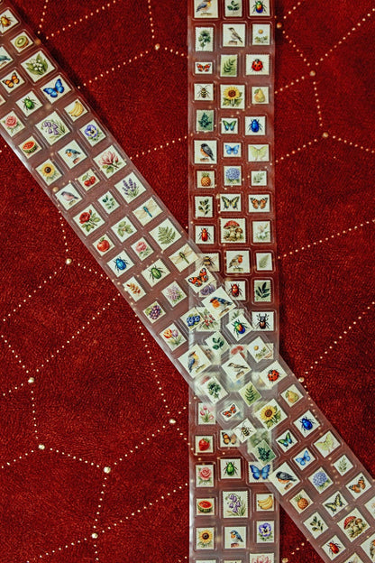 Transparent tape strip covered with mini postage stamps, folded and arranged in an S shape