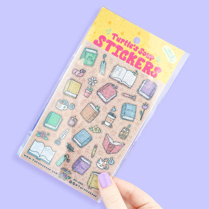 Glitter sticker sheet held in hand, featuring books and stationery icons