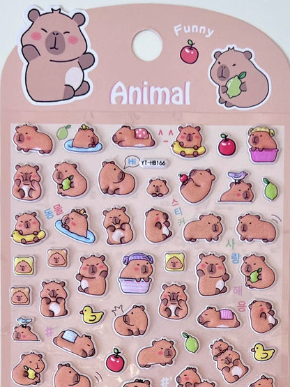 Close-up of animal sticker sheet with cartoon capybara faces, fruit, and small objects