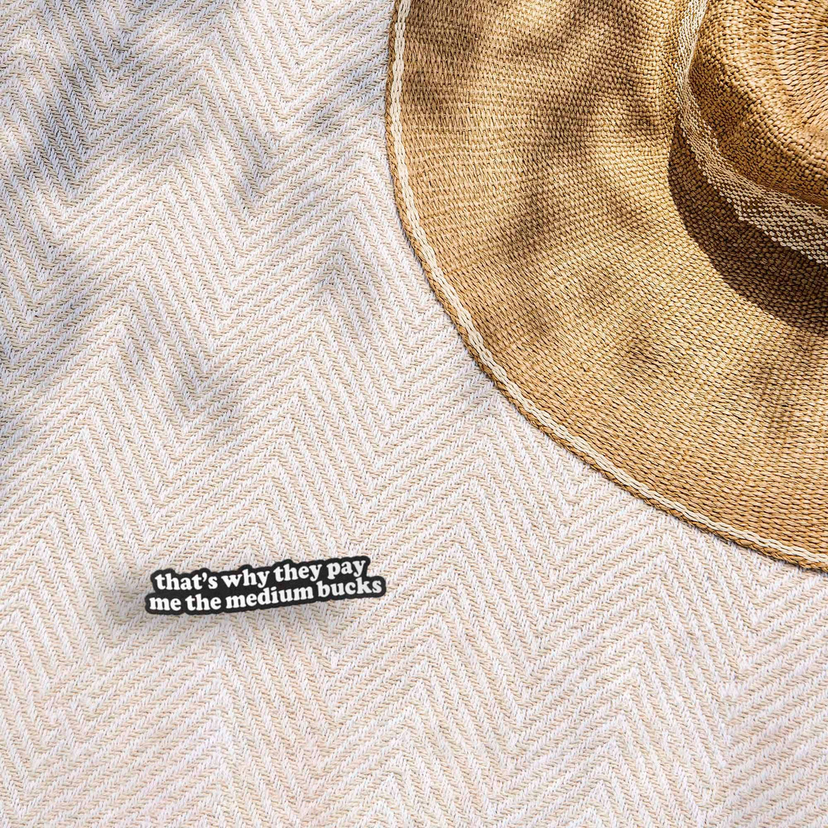 Funny quote sticker on light textured fabric: 'that's why they pay me the medium bucks'