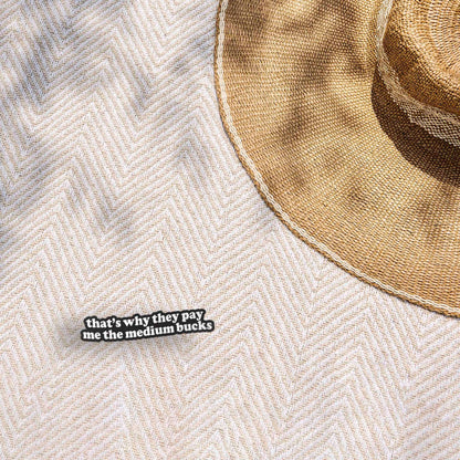 Funny quote sticker on light textured fabric: 'that's why they pay me the medium bucks'