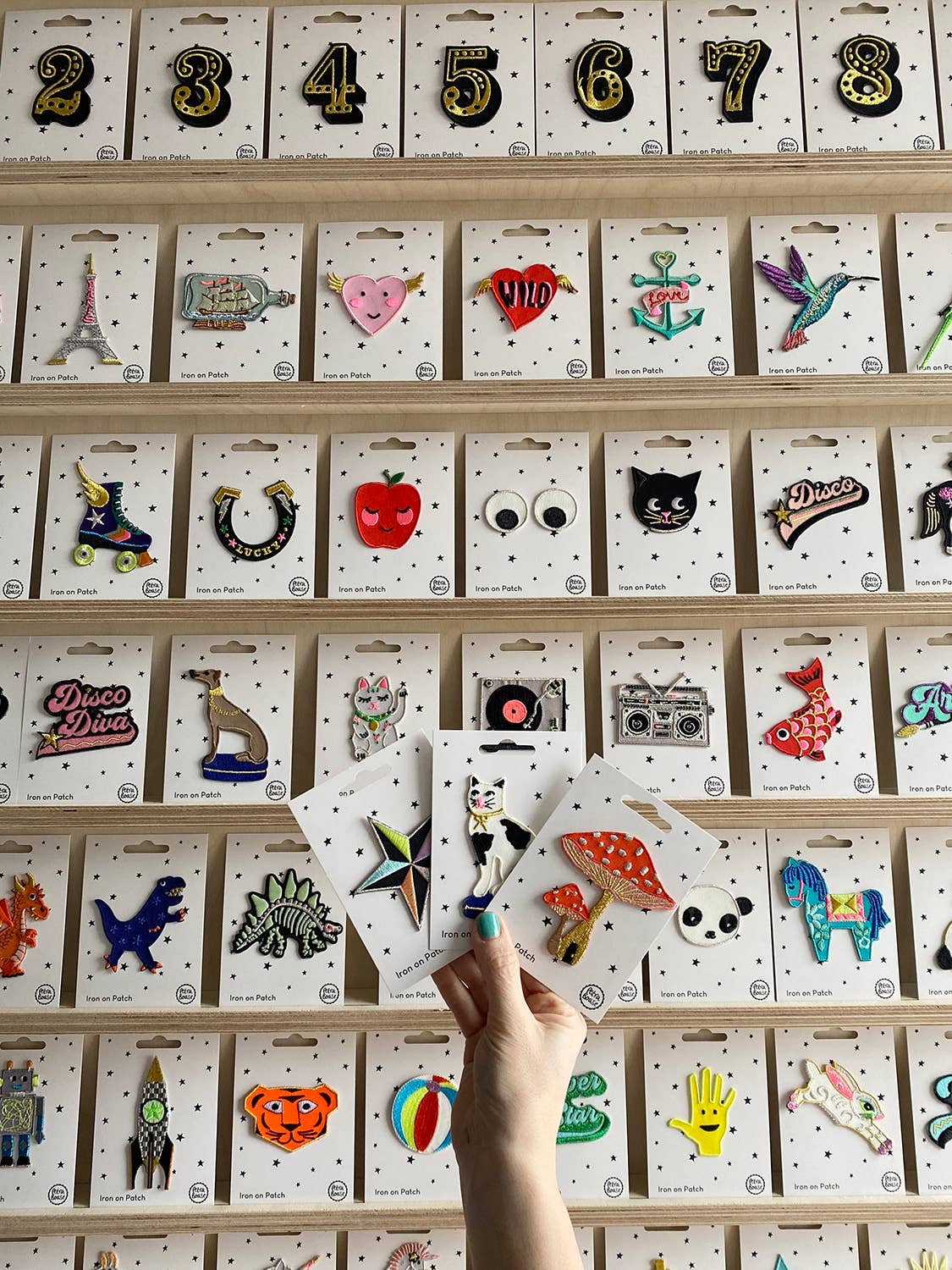 Assorted iron-on patch cards displayed in rows with various colorful patch designs