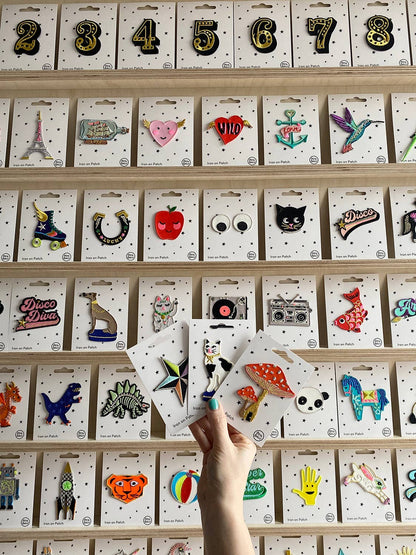 Assorted iron-on patch cards displayed in rows with various colorful patch designs