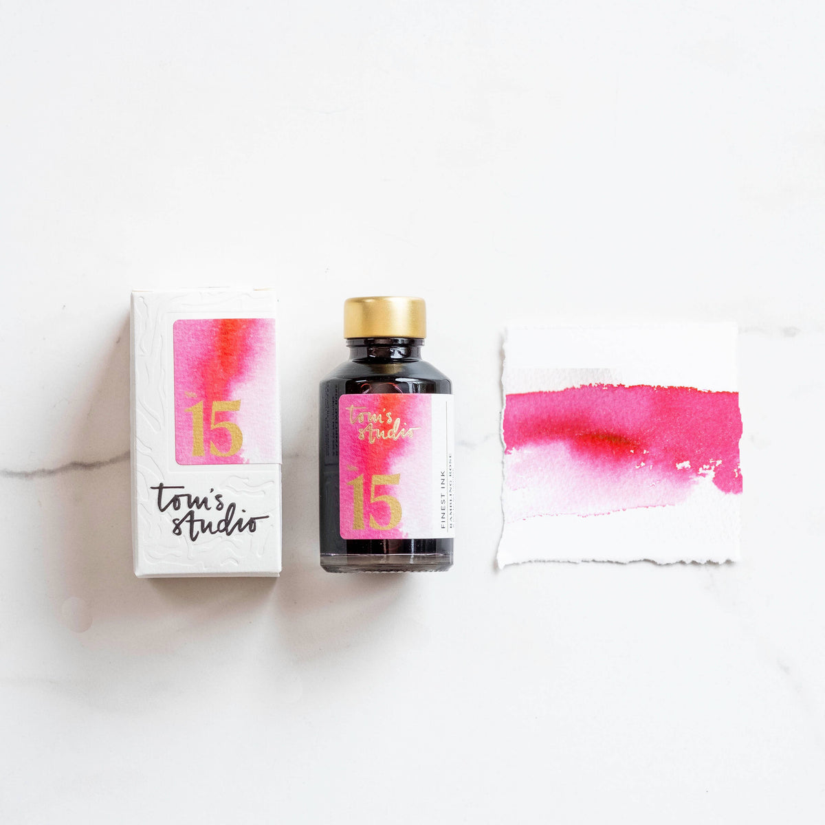 Fountain pen ink bottle with pink ink swatch and label on white box