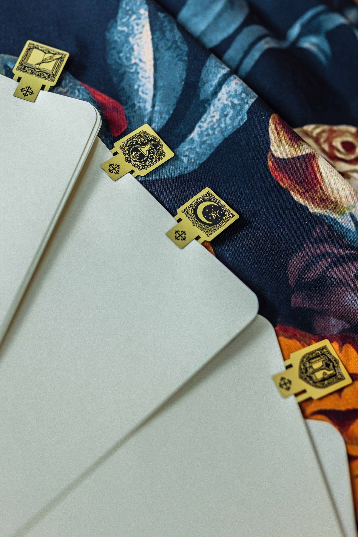 Blank notebook pages with small gold square page markers and circular emblem