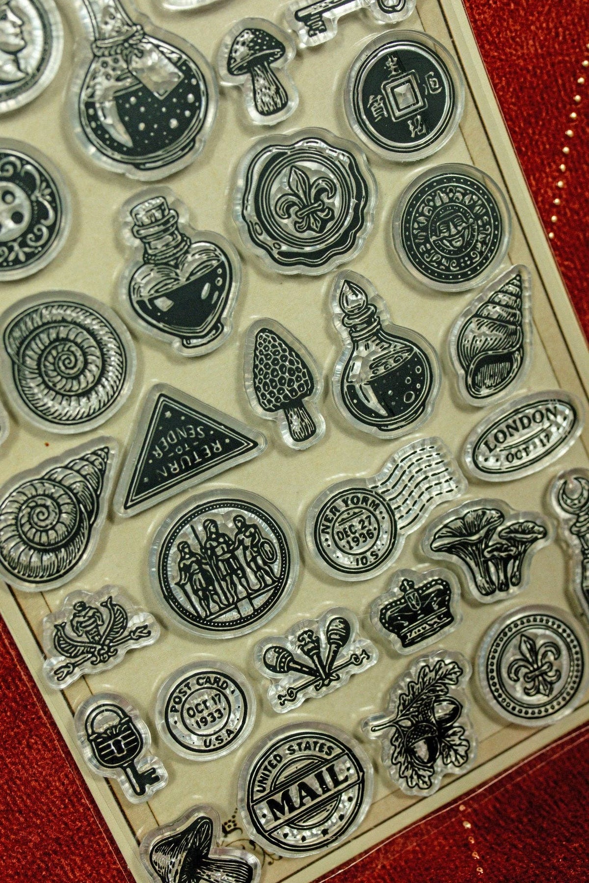 Clear acrylic stamp set close-up with mail, cacti, gears, and bottle icons