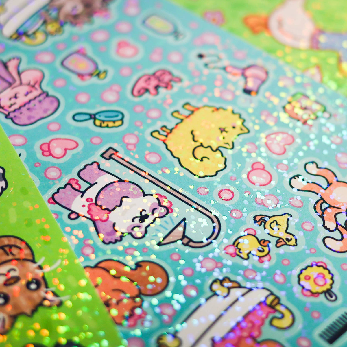 Close-up of glitter sticker sheet with pastel objects, cats, and heart icons