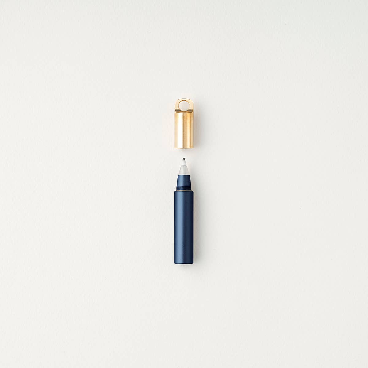 Midnight refillable travel pen with open gold cap and blue barrel tip
