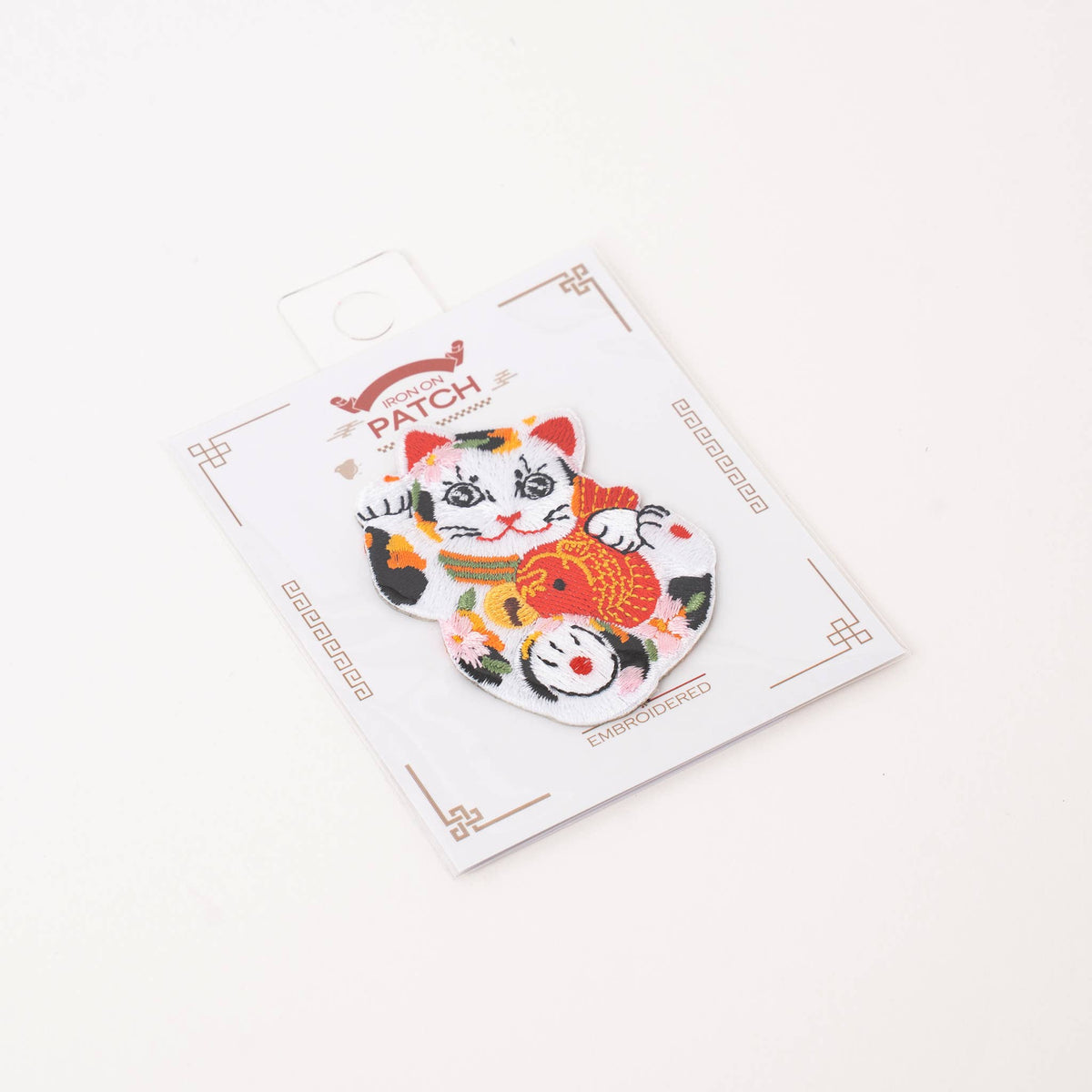 Lucky cat iron-on patch packaged on retail card