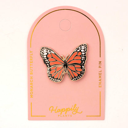 Monarch butterfly pin on a pink backing card with gold-tone details.