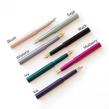 Assorted colored pocket fountain pens with gold nibs laid out together.