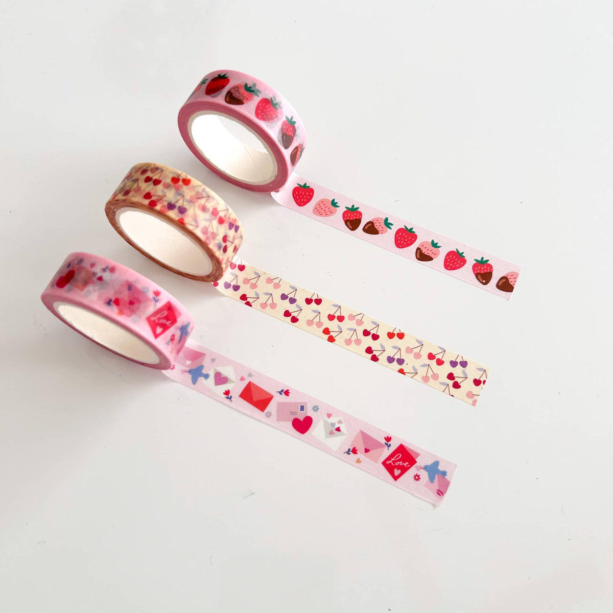 Three washi tapes with strawberry and berry prints, hearts, and chocolate motifs