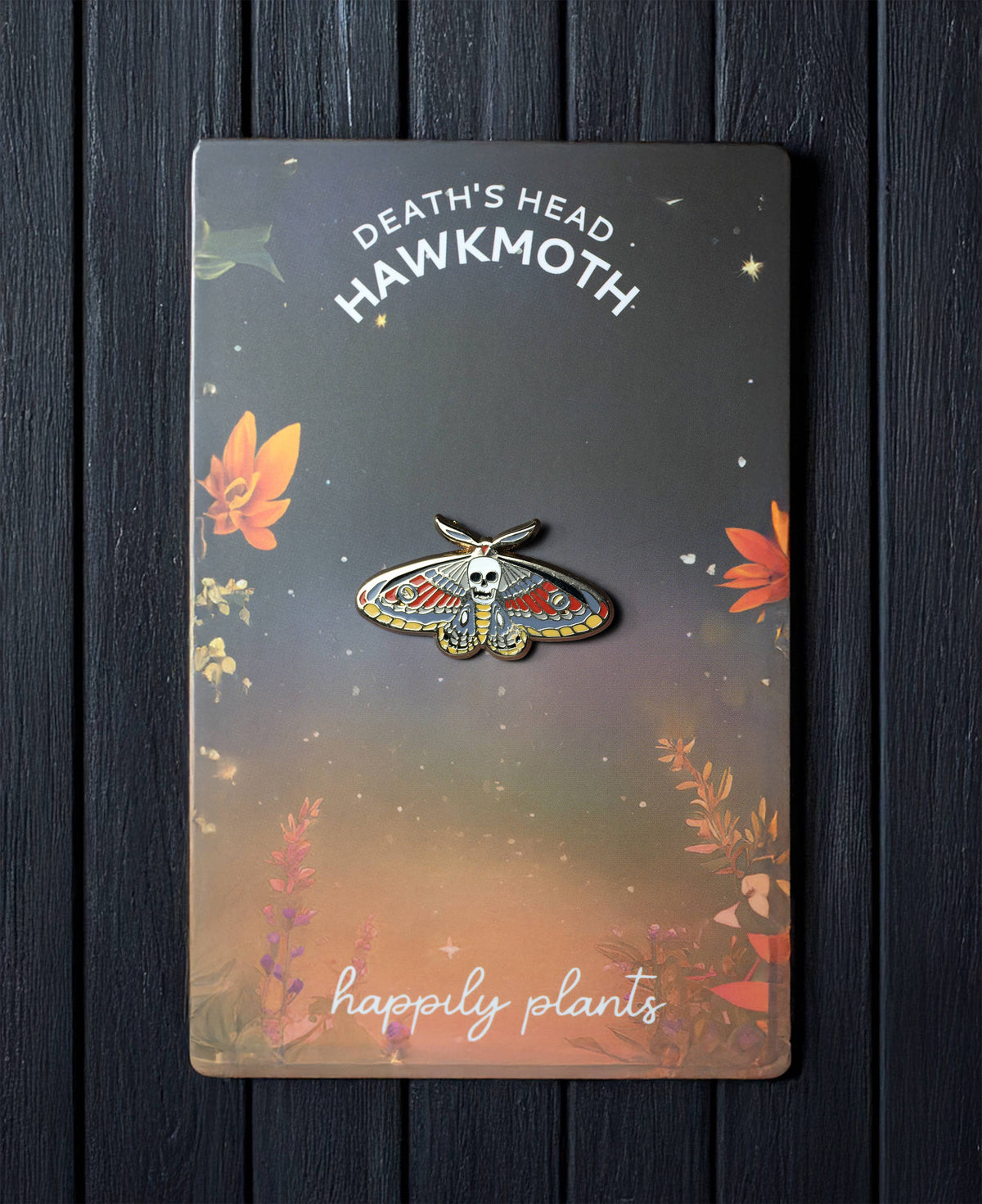 Death moth skull pin card with illustrated moth emblem and gold-toned pin