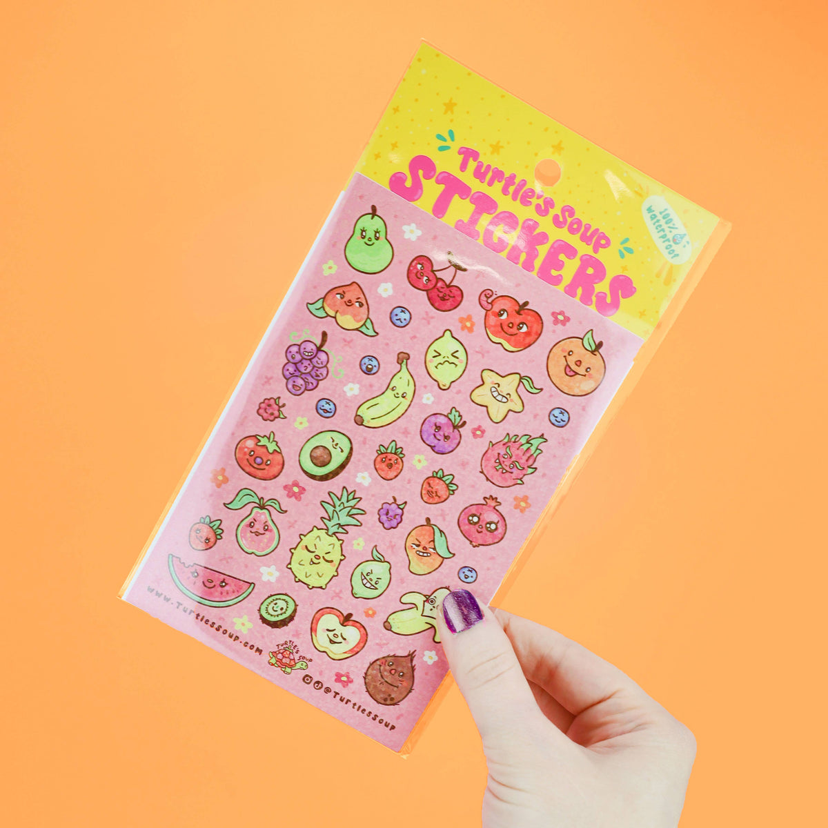 Cute fruit sticker sheet held at angle, colorful kawaii icons and glitter details