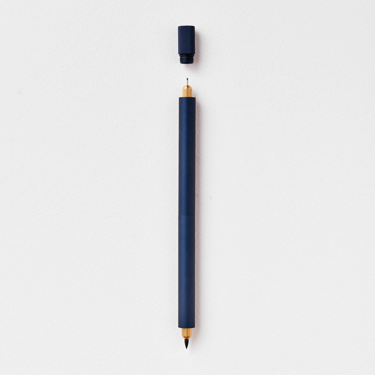 Midnight blue refillable multi-tip pen, uncapped writing tip visible