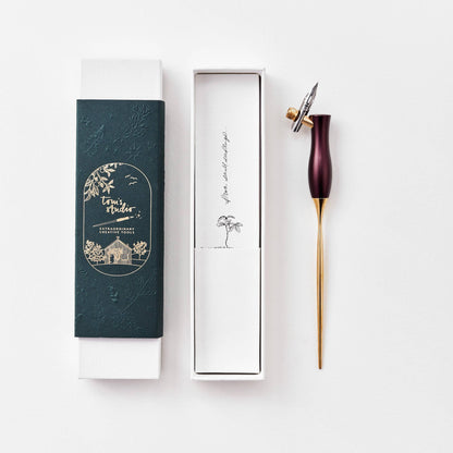 Calligraphy pen with burgundy handle, gold nib, shown with gift box