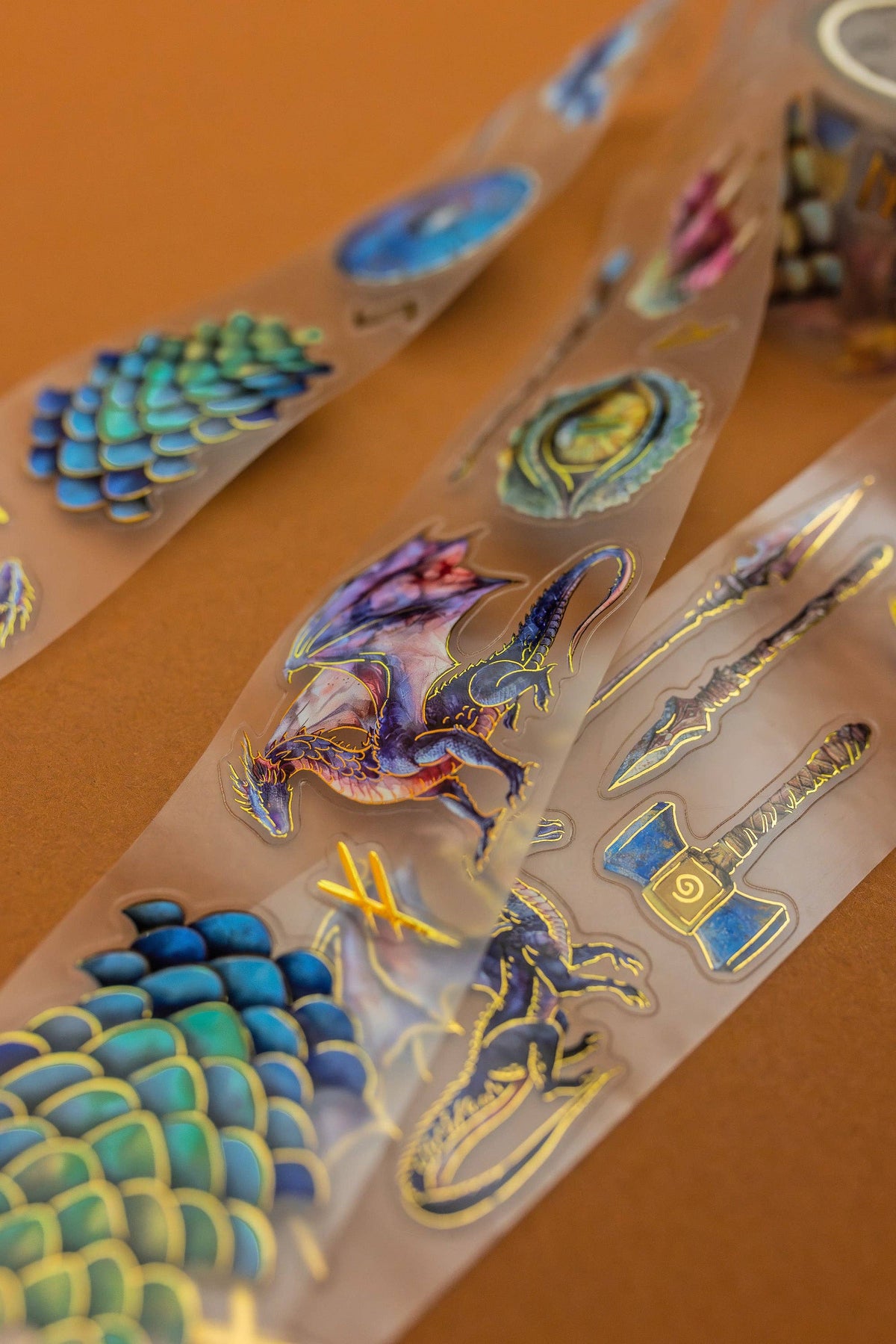 Transparent tape strip with holographic dragon, scales, and lightning icons