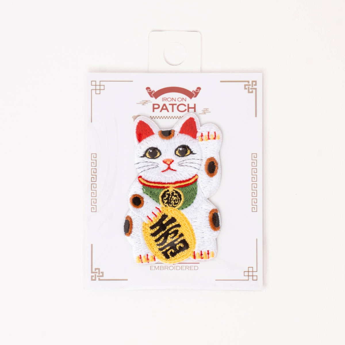 Iron-on lucky cat patch on retail card, white cat with red accents and gold coin