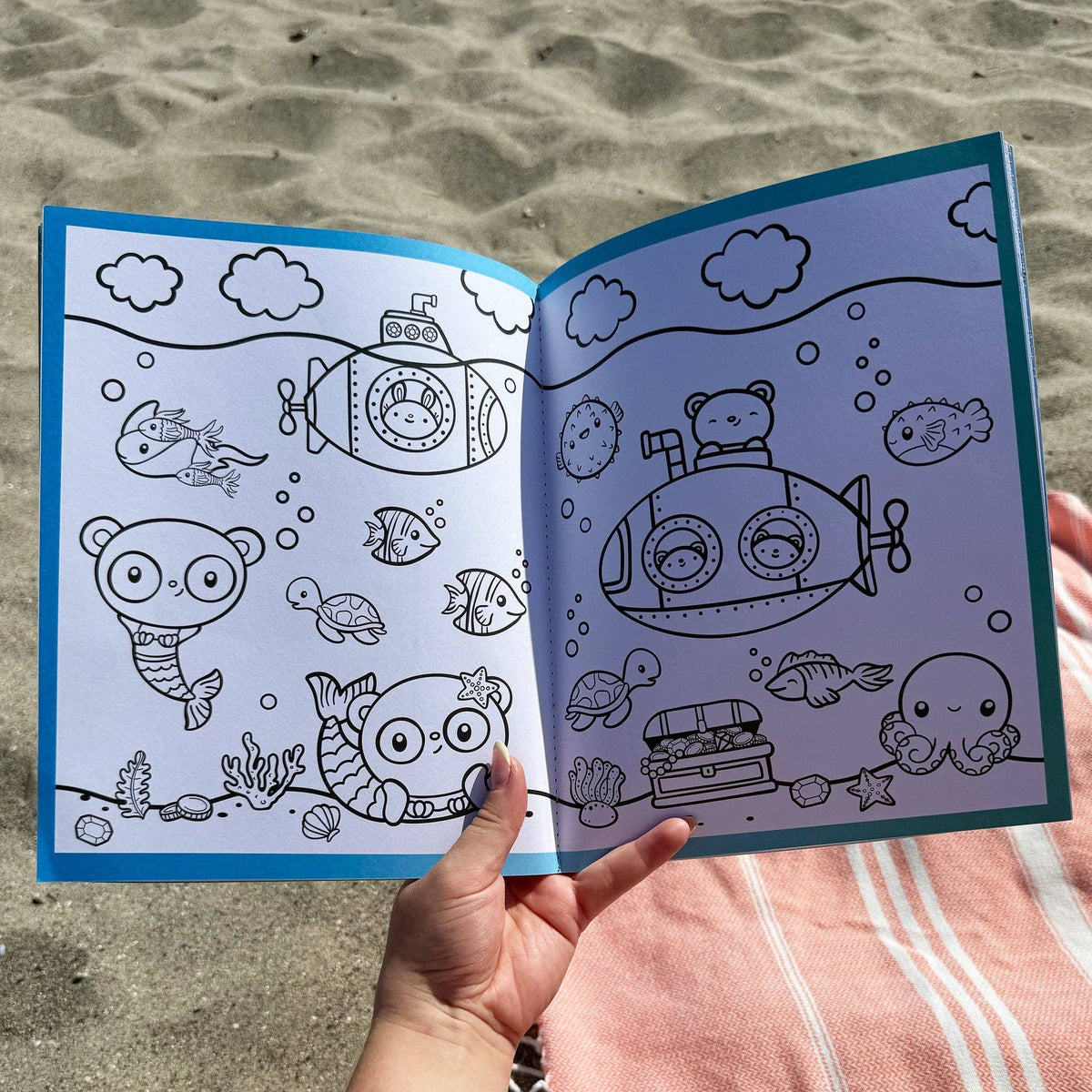 Sea life sticker book open to blue-outlined submarine and sea creature line art